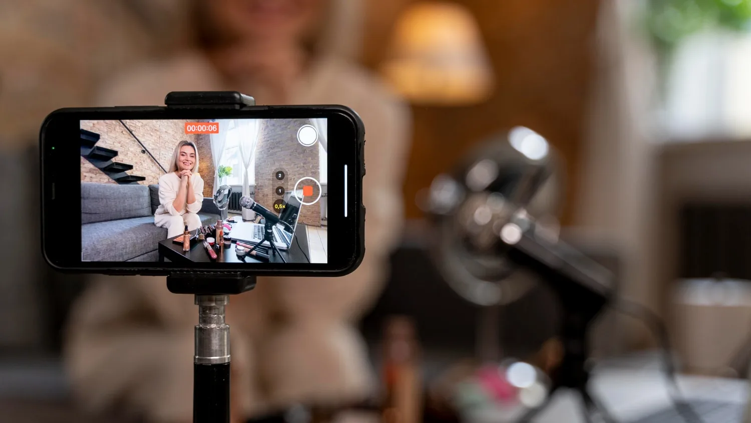 Entrepreneur filmant une vidéo TikTok avec un smartphone sur trépied dans son atelier