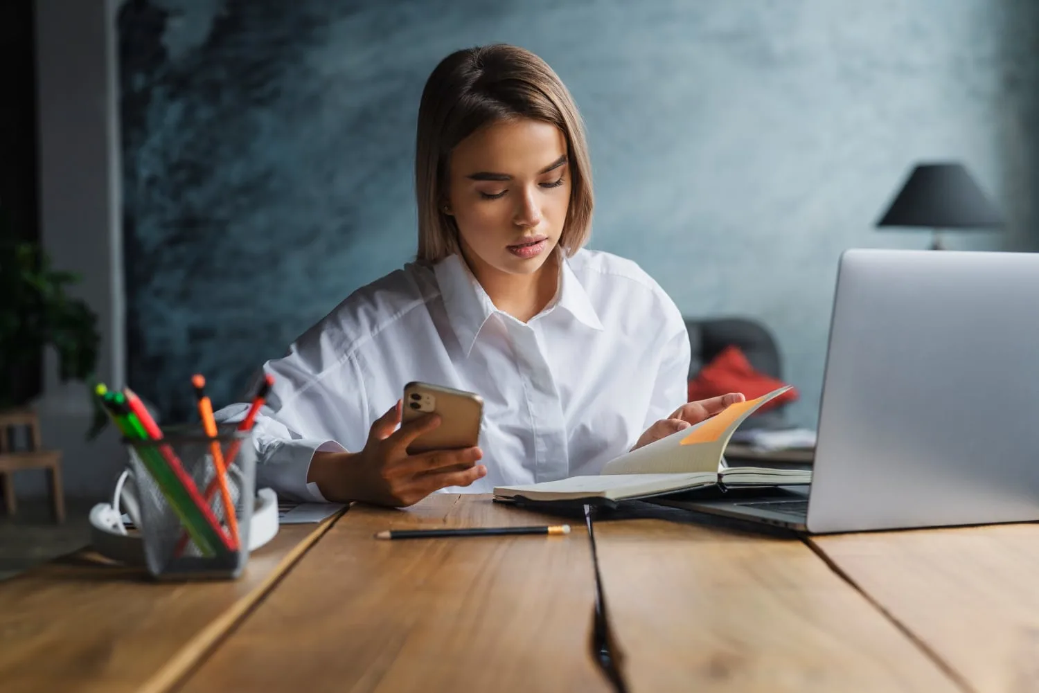 Une entrepreneure en visioconférence, avec ordinateur portable, carnet de notes et documents de carrière sur un bureau rangé