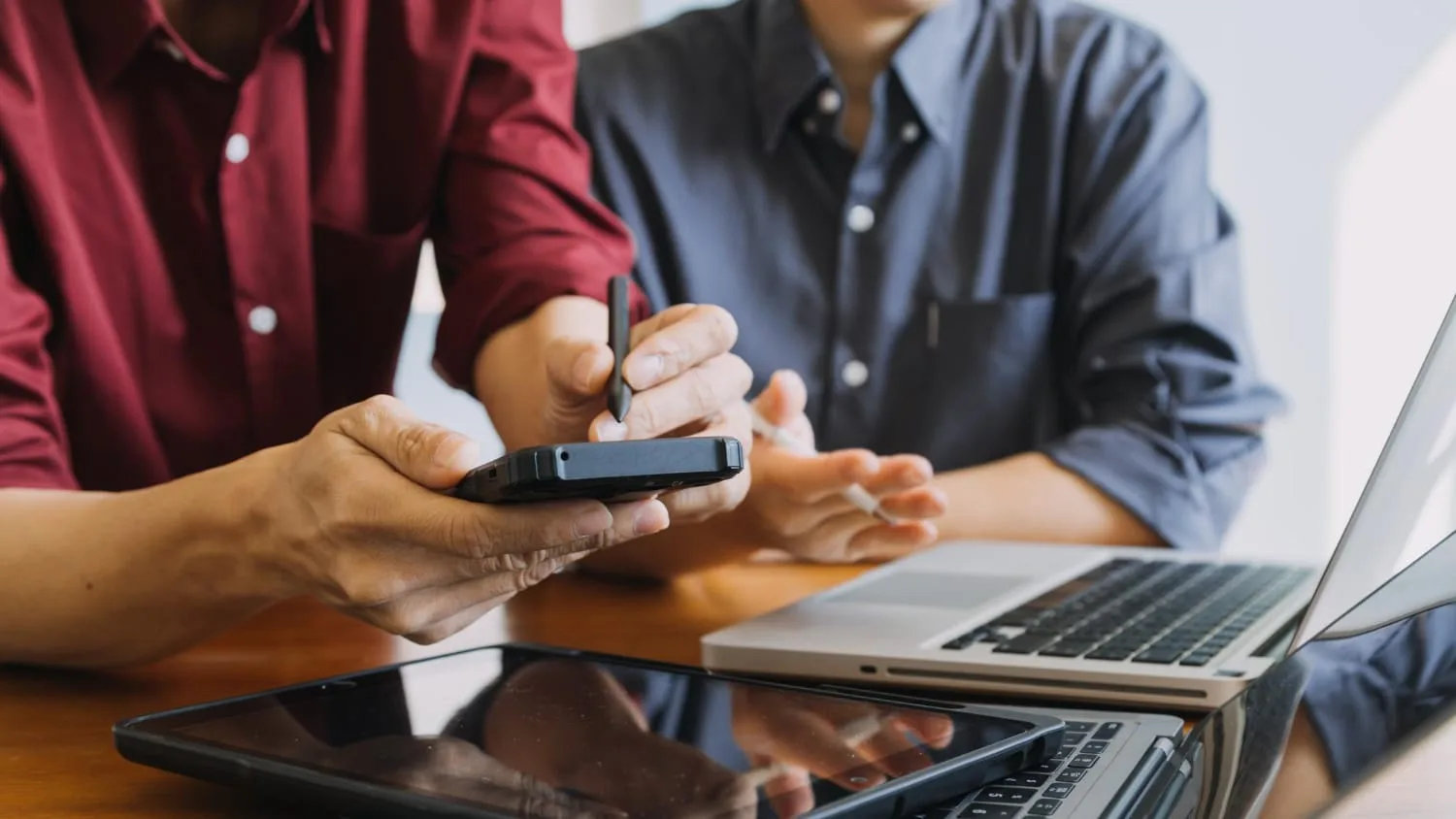 Entrepreneur consultant un dossier de financement avec devis, calculatrice et ordinateur portable sur un bureau