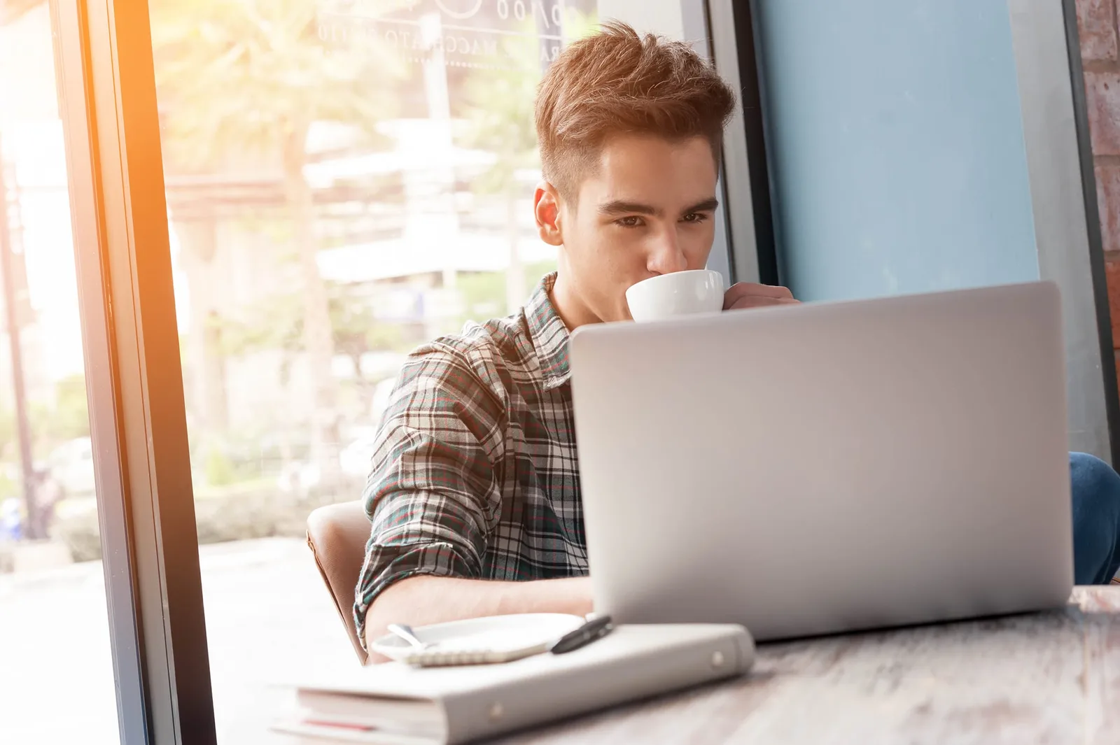 Entrepreneur individuel travaillant seul à son bureau avec ordinateur, factures et documents administratifs