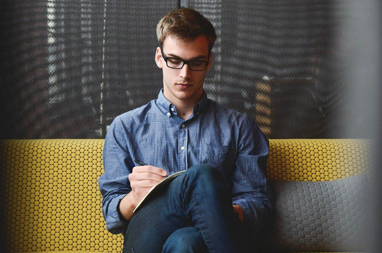 Une entrepreneuse remplit un dossier de création d’entreprise sur un ordinateur portable, avec des documents administratifs à côté.