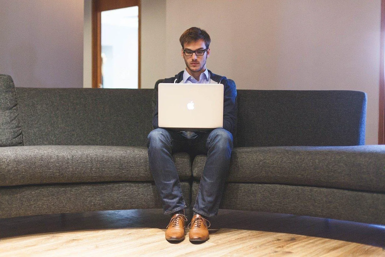 Entrepreneur comparant des documents de statut juridique avec un ordinateur portable sur un bureau