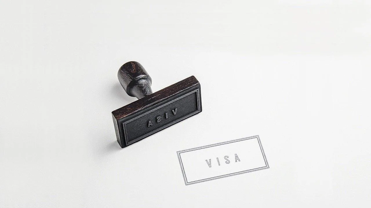 Un entrepreneur étranger remet son dossier de visa au guichet d’un consulat français avant un déplacement professionnel