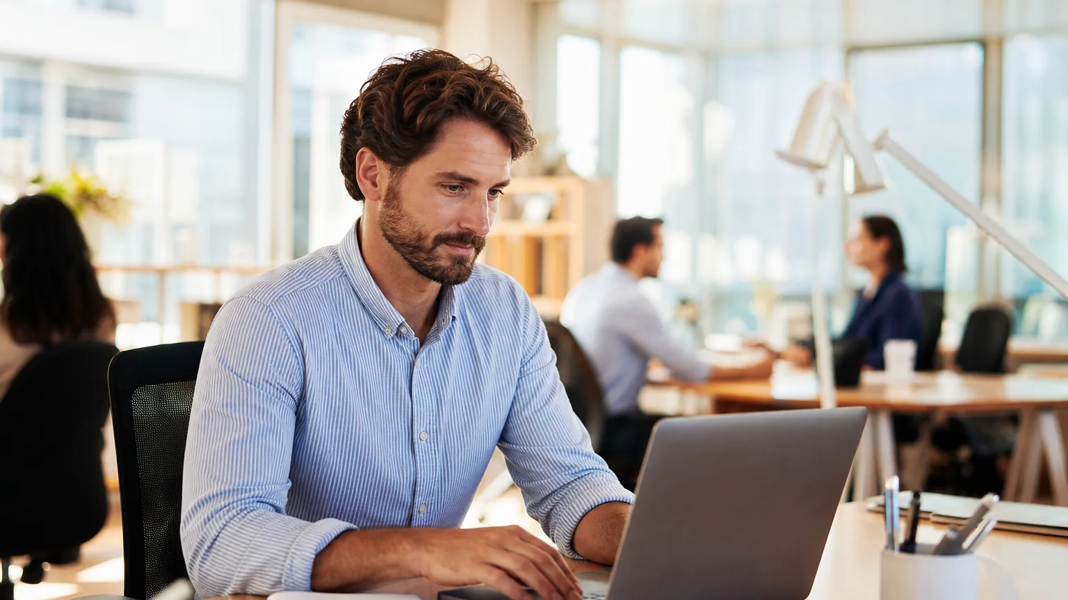 Indépendant travaillant sur son ordinateur portable dans les locaux d'un client, illustrant le risque de requalification en salariat