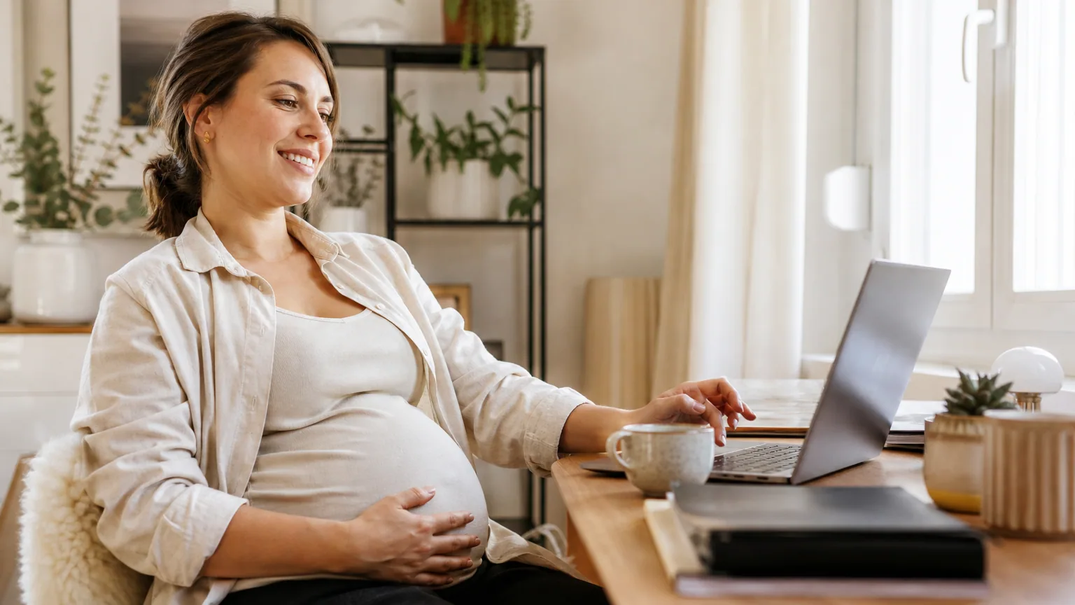 Micro-entrepreneure enceinte travaillant sereinement depuis son bureau à domicile, ambiance chaleureuse et lumineuse
