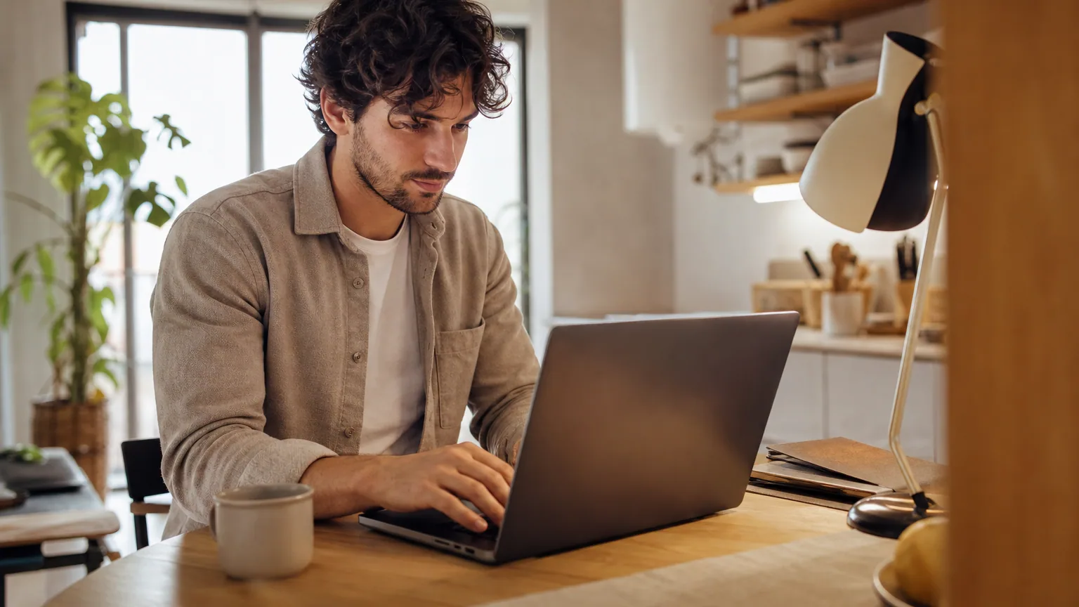 Salarié en CDI travaillant le soir sur son ordinateur portable à la maison sur son activité de micro-entrepreneur