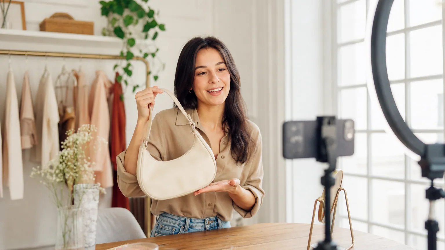 Créatrice de contenu filmant une vidéo de présentation de produit avec un smartphone sur trépied et un anneau lumineux