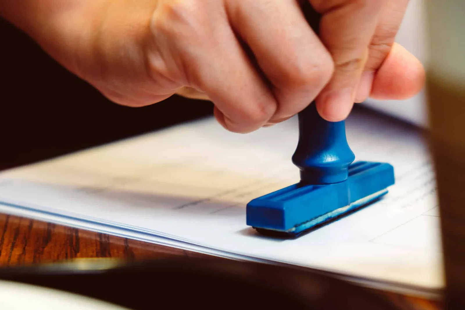 Tampon encreur d’entreprise posé à côté d’un devis, d’une facture et d’un stylo sur un bureau
