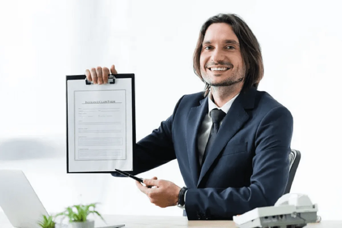 Un entrepreneur consulte son contrat d’assurance professionnelle avant d’envoyer une demande de résiliation.