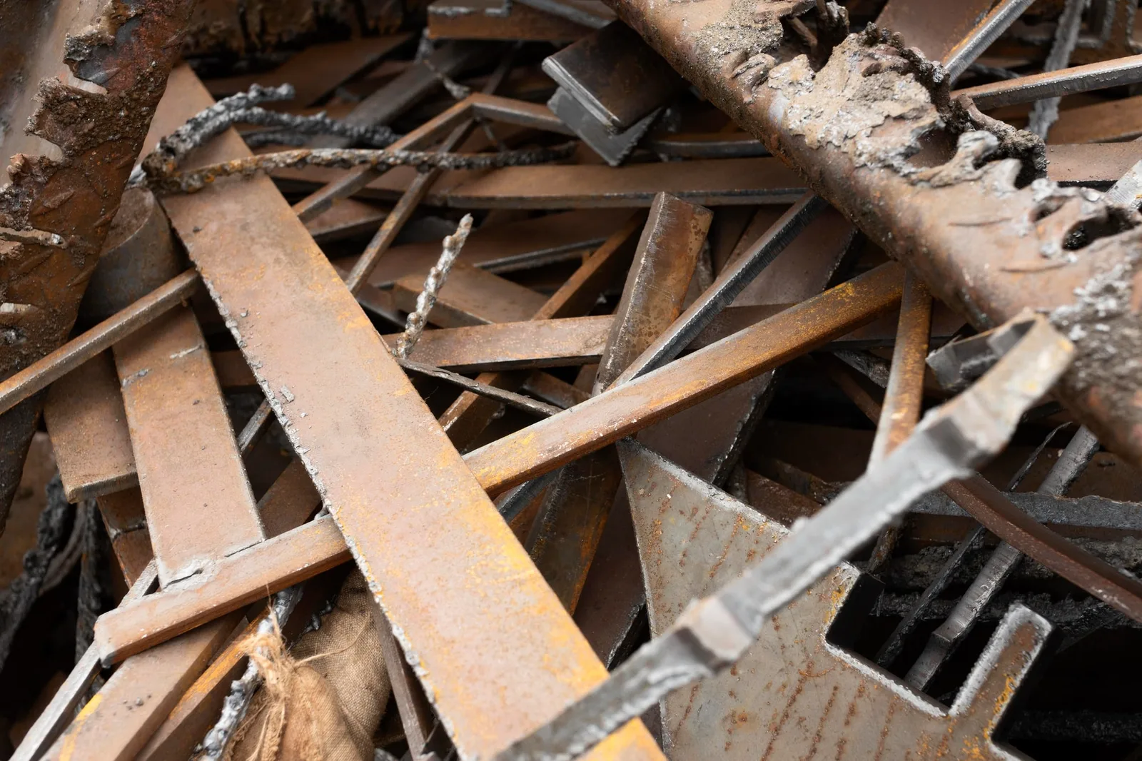 Photo d’une benne de ferraille triée sur site industriel, avec chutes de métal, câbles et pièces métalliques prêts à être collectés.