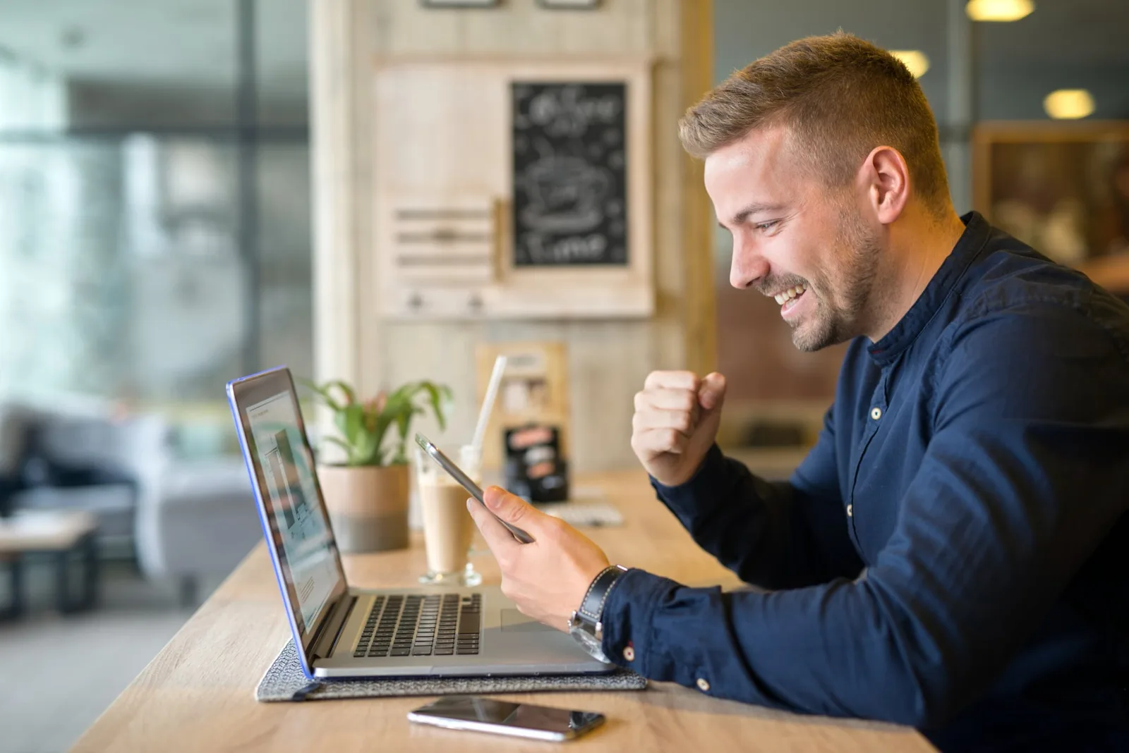 Un auto-entrepreneur consulte ses impôts sur ordinateur, avec des documents comptables et une calculatrice sur son bureau.