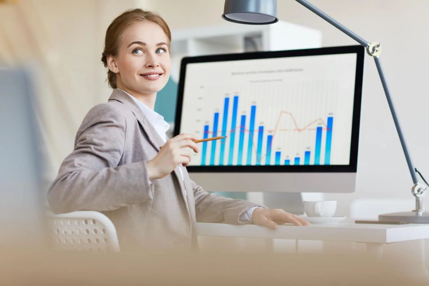 Un data analyst travaillant sur un ordinateur avec des graphiques de performance et des tableaux de bord affichés à l’écran
