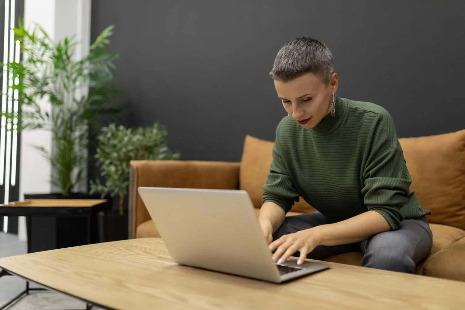 Entrepreneur en visioconférence avec un partenaire étranger, ordinateur ouvert, documents et notes en plusieurs langues sur le bureau.
