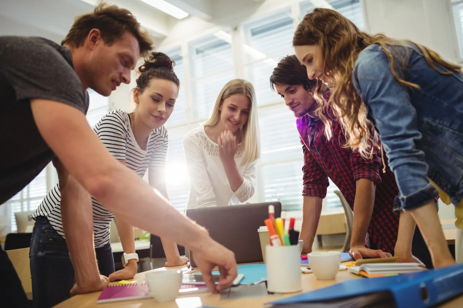 Un dirigeant échange avec une candidate en entretien dans un bureau lumineux, devant un tableau de plan de recrutement.